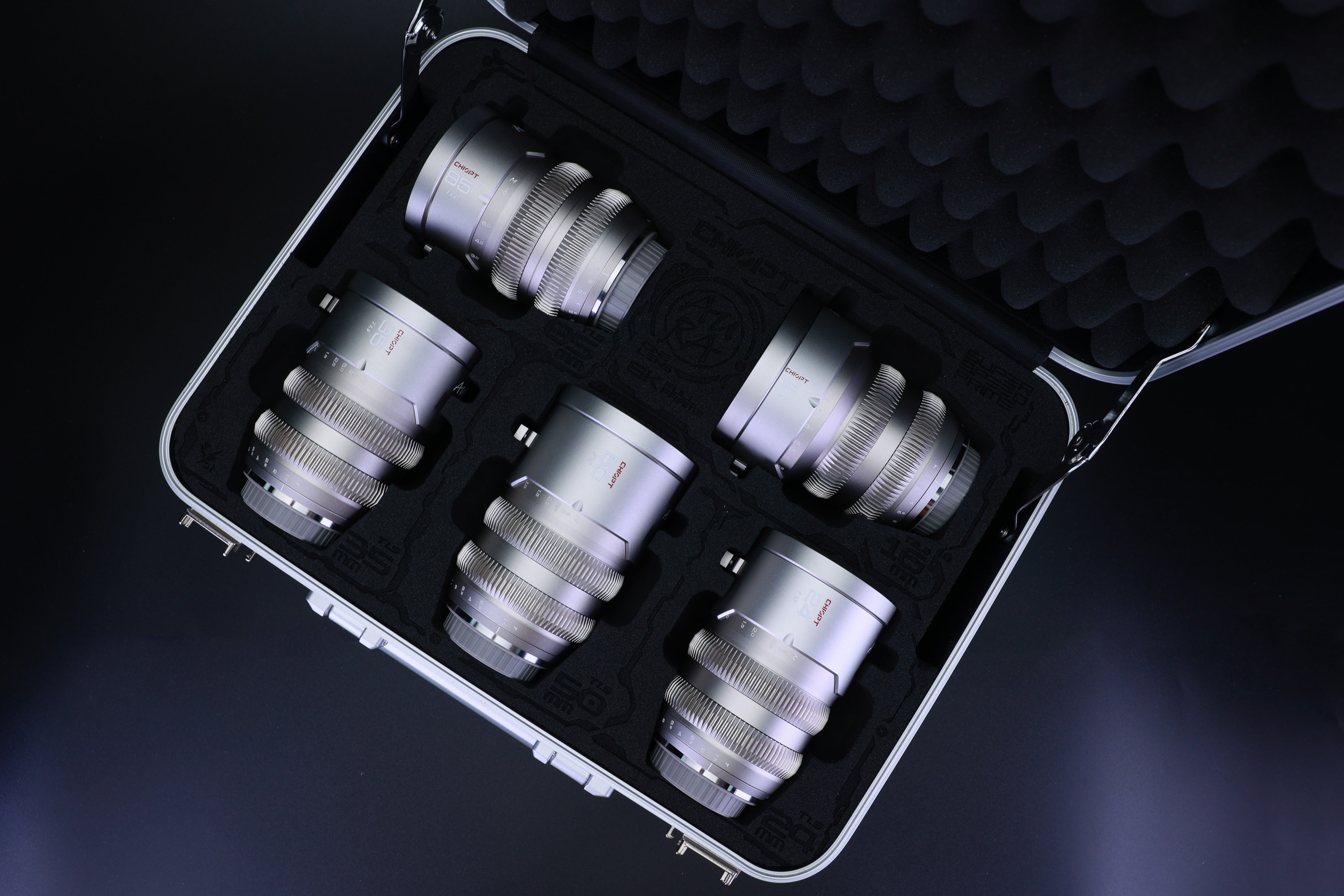 Chiopt Aura Super Speed Prime Lens silver kit with secure reinforced flight case, including 16mm T2.2, 24mm T1.5, 35mm T1.5, 50mm T1.5, and 85mm T1.5 classic cine lenses, designed for professional filmmakers needing versatile, fast aperture lenses for high-end video production.