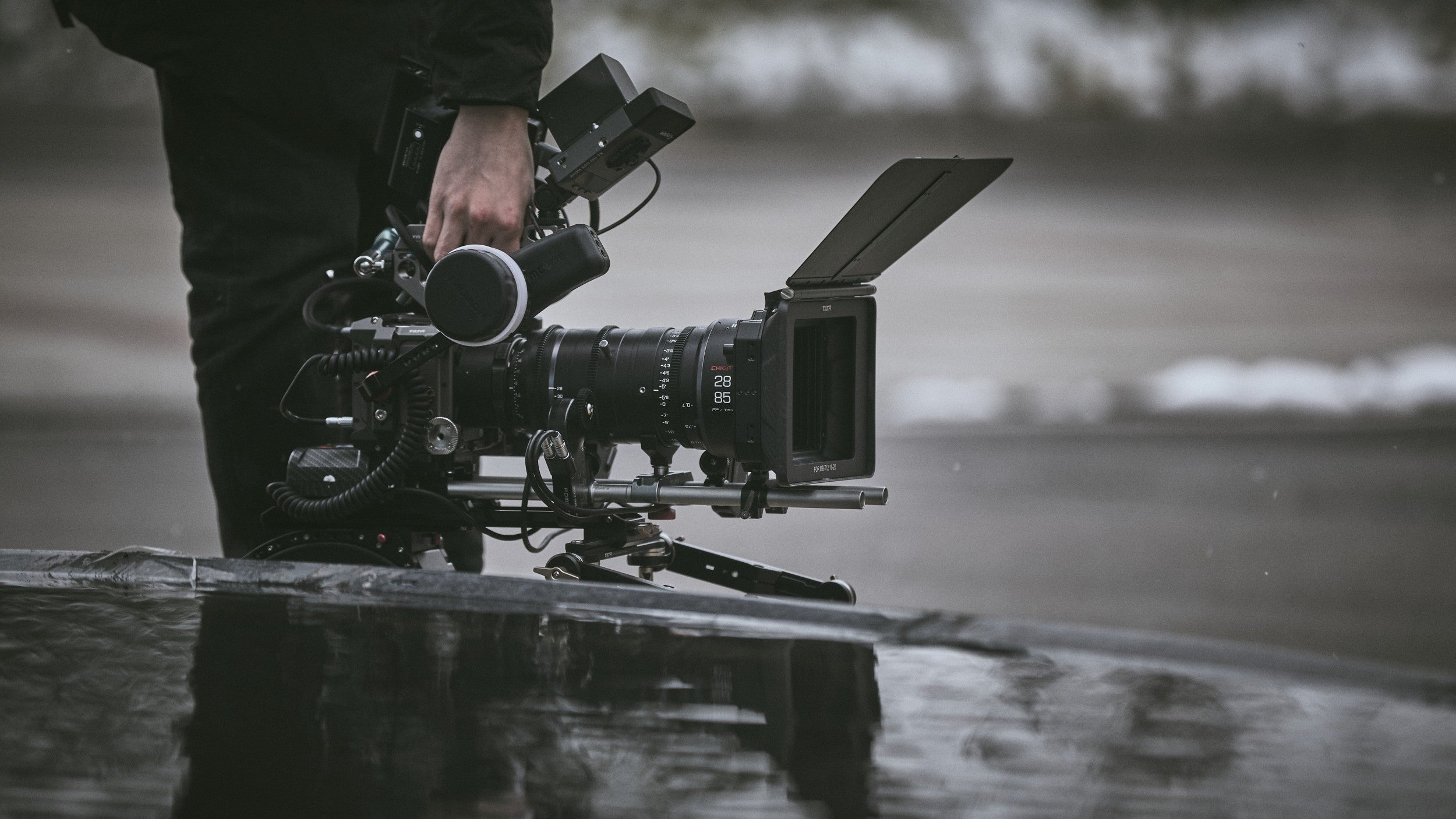 Chiopt Xtreme Zoom 28-85mm cine lens mounted on professional camera with filmmaking accessories setup, ideal for cinematographers, documentary filmmakers, and videographers. Perfect for outdoor shoots, event filming, narrative cinema, and versatile video production with dustproof, rain-resistant design.