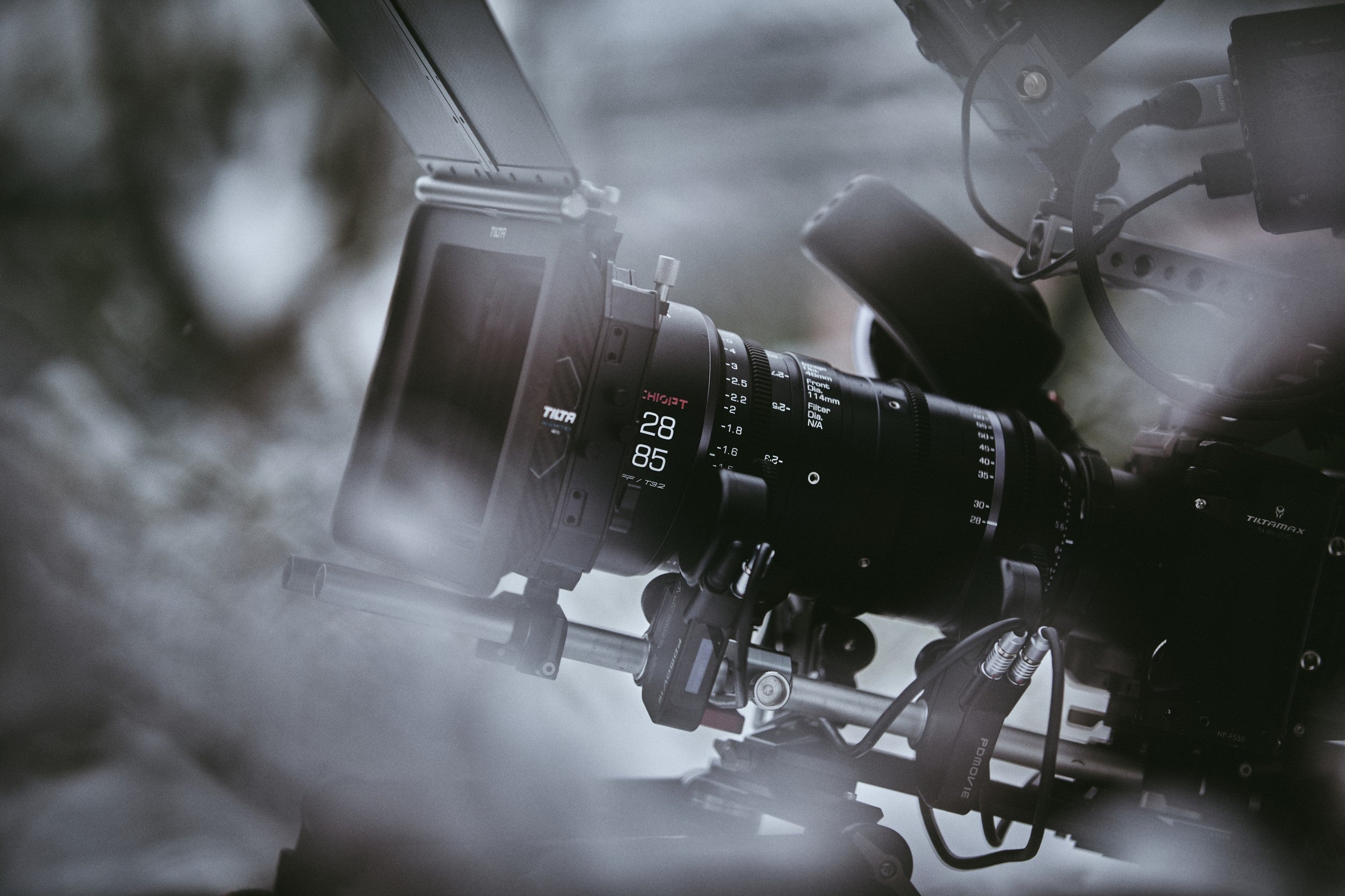 Chiopt Xtreme Zoom 28-85mm T3.2 cine lens with wide compatibility, fully equipped with professional filmmaking accessories including rail system, matte box, filters, follow focus, and motorized control devices for versatile shooting setups.