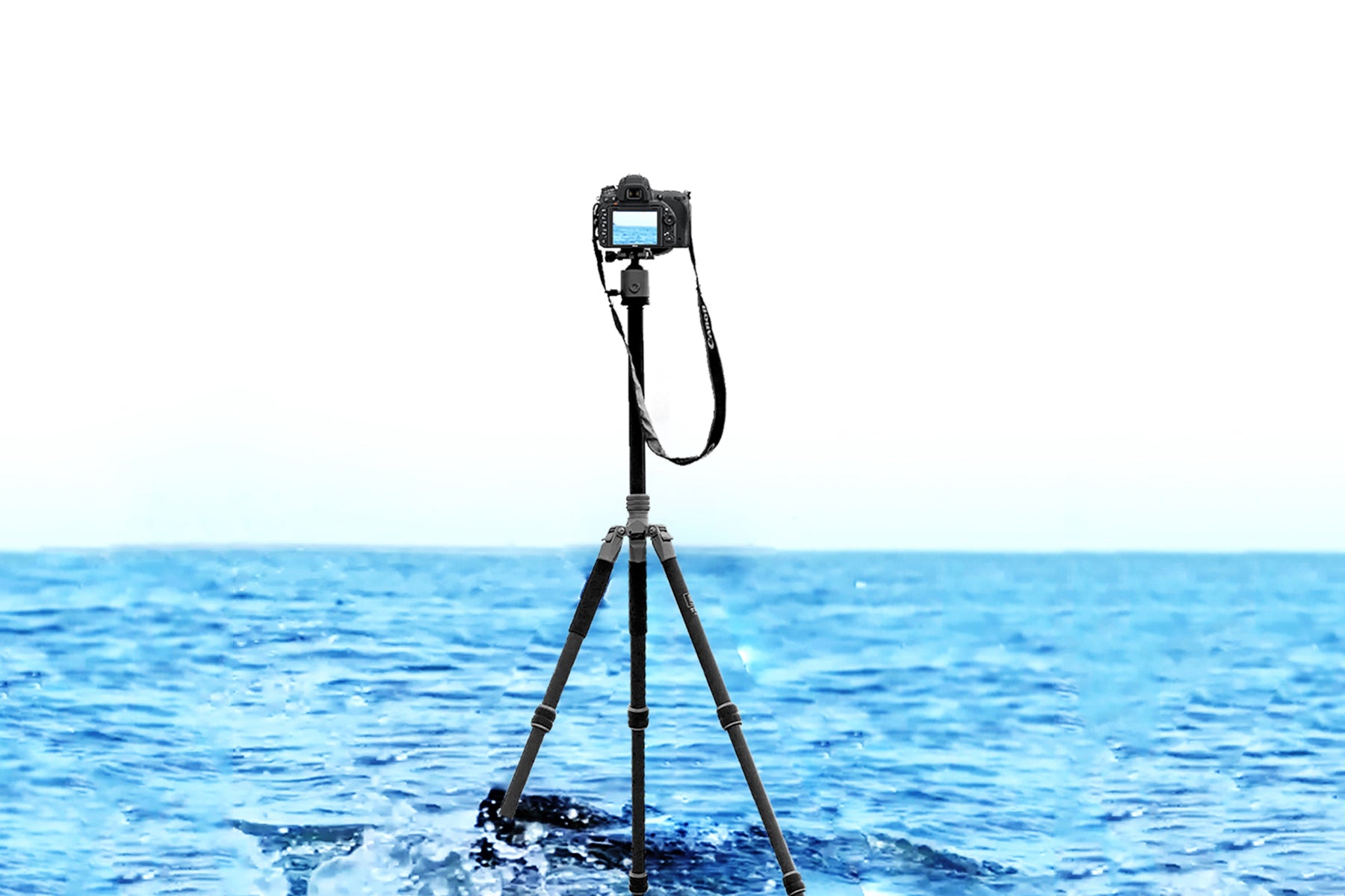 Fotopro T-ROC tripod standing in seawater while waves crash against it, demonstrating its stability under impact and resistance to salt corrosion after 50°C 5% salt spray testing. Camera Tripod from the T-ROC Series enduring ocean wave impact during a coastal shoot, showcasing long-lasting durability and anti-corrosion performance in saltwater environments.