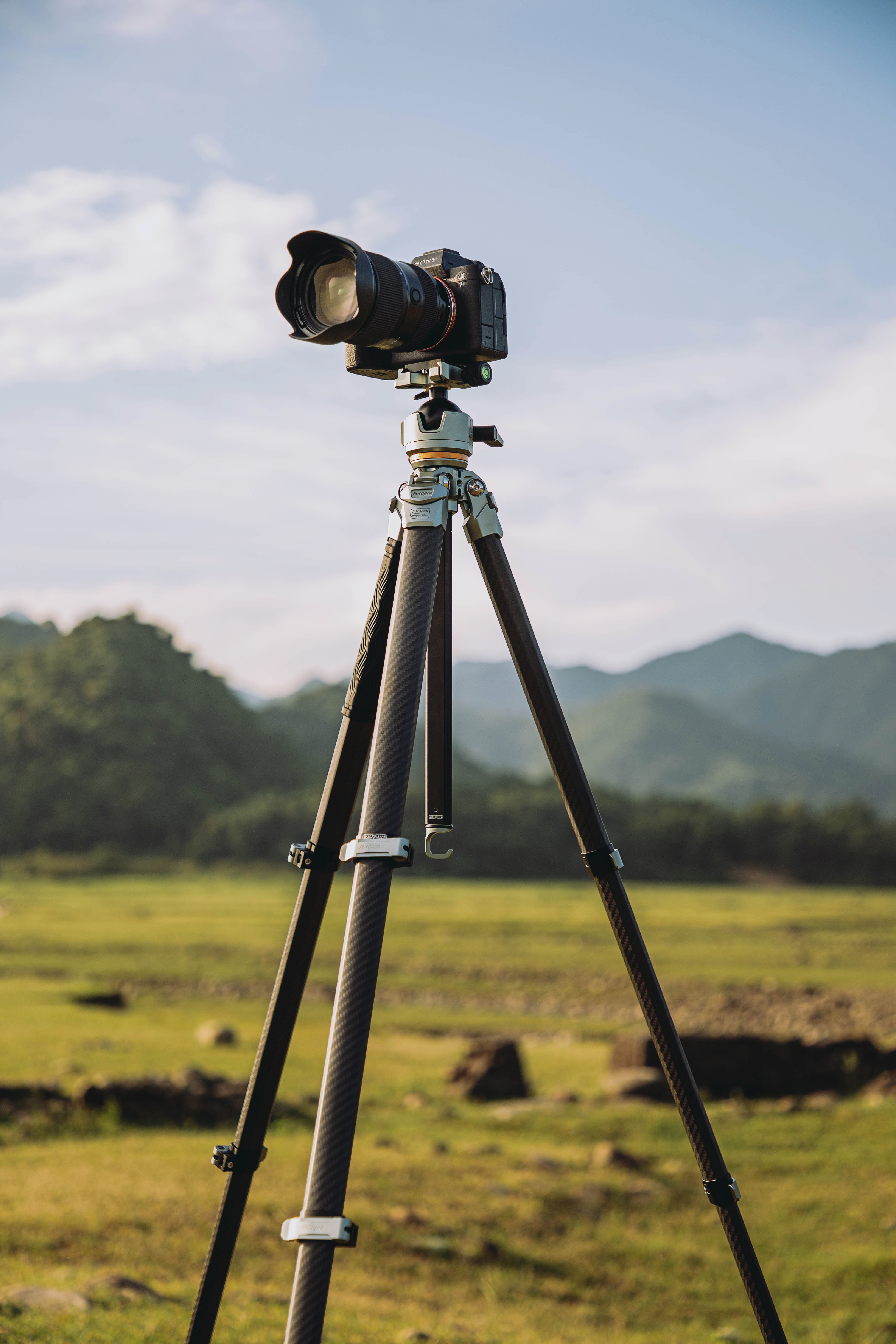 Fotopro Origin Plus silver lightweight travel tripod in use with camera, legs fully extended, compact and portable tripod for photography and video shooting.