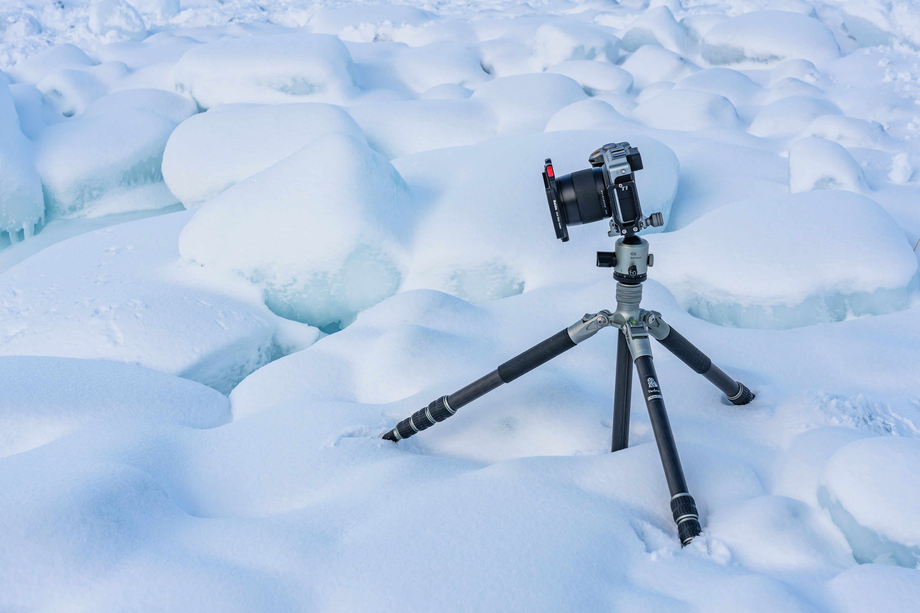 Tripod from the T-ROC Series standing firmly in a snowy landscape, highlighting its ability to function in sub-zero temperatures, with anti-freeze, anti-corrosion, and dust-sealed features.