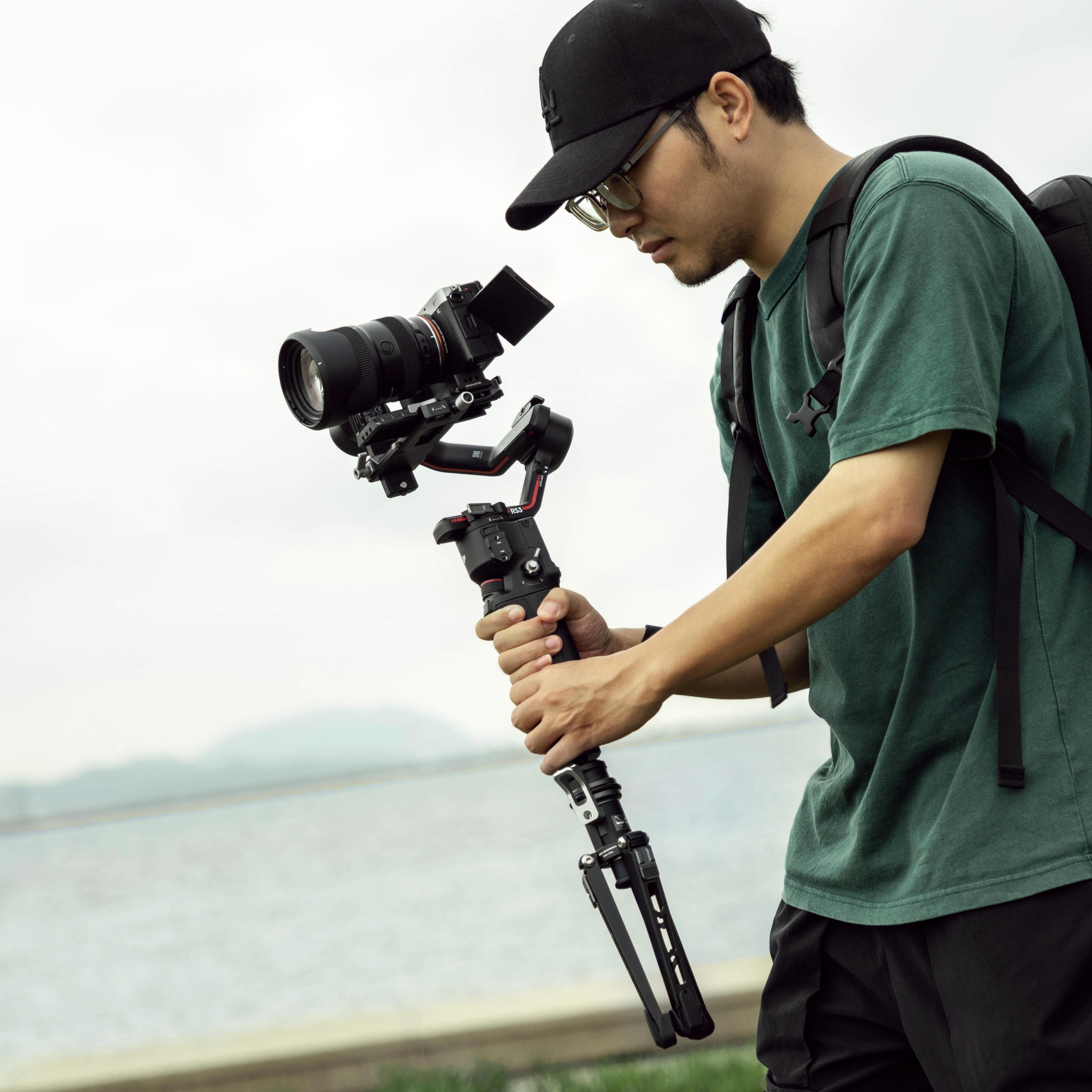 Photographer using Fotopro X-Airfly Mono in mini tripod mode with stabilizer for handheld video shooting