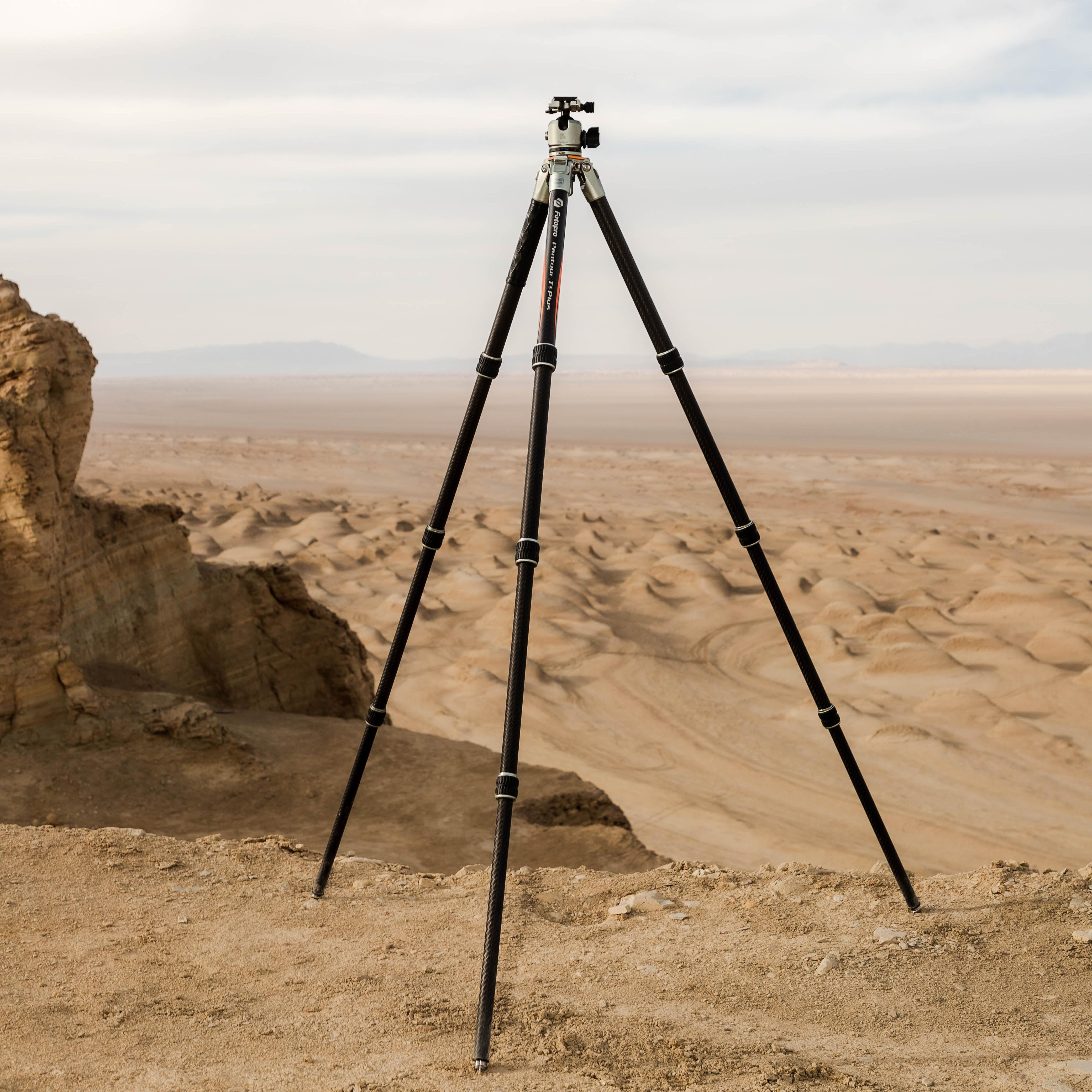 Fotopro T1 Plus carbon fiber tripod lifestyle shot in desert, dustproof, waterproof, weather-resistant, ideal for travel, outdoor, and extreme terrain photography.