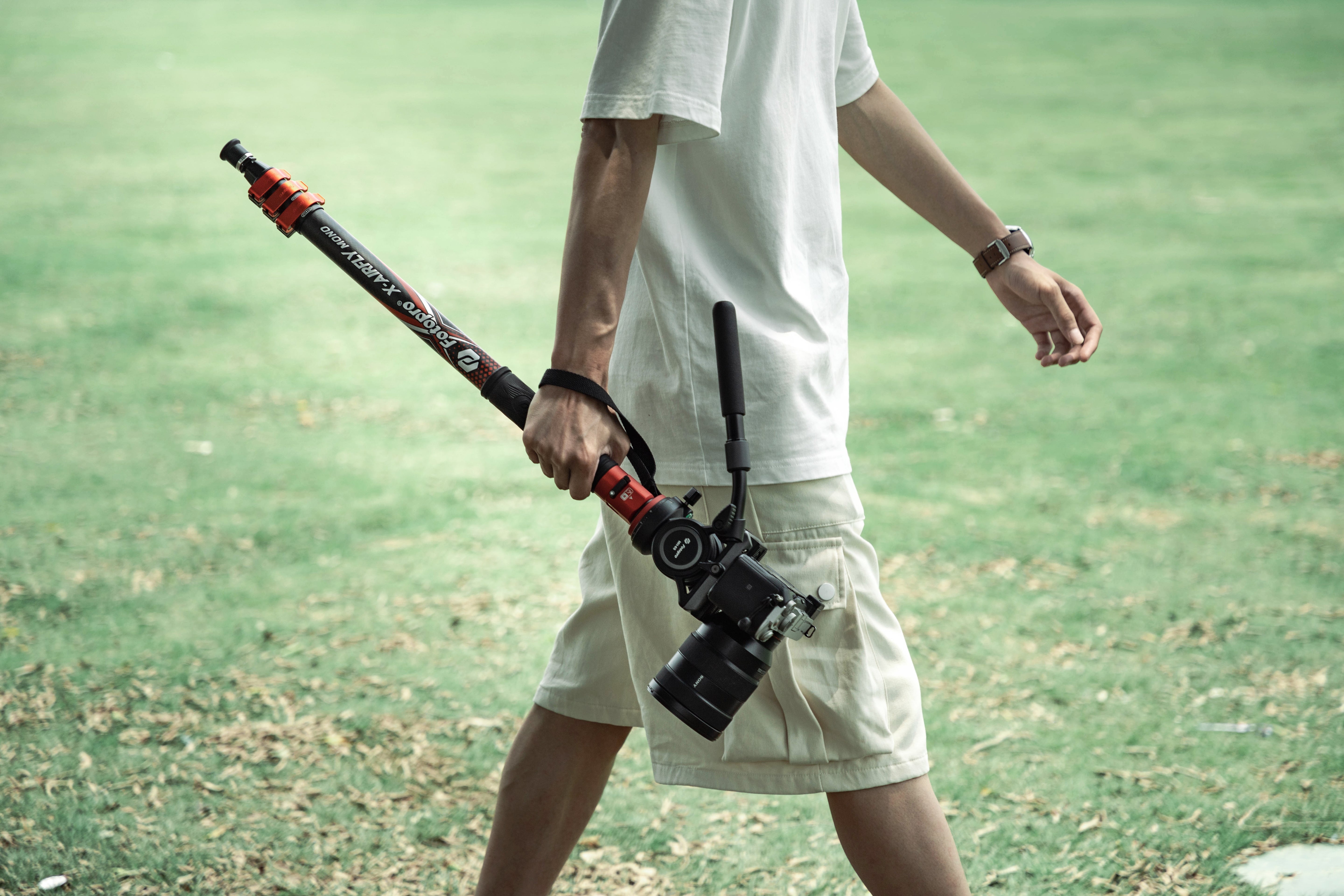 Fotopro X-Airfly Mono travel monopod with fluid video head for camera, lightweight and easy to carry with one hand, available in orange and grey, ideal for portable video shooting and photography.