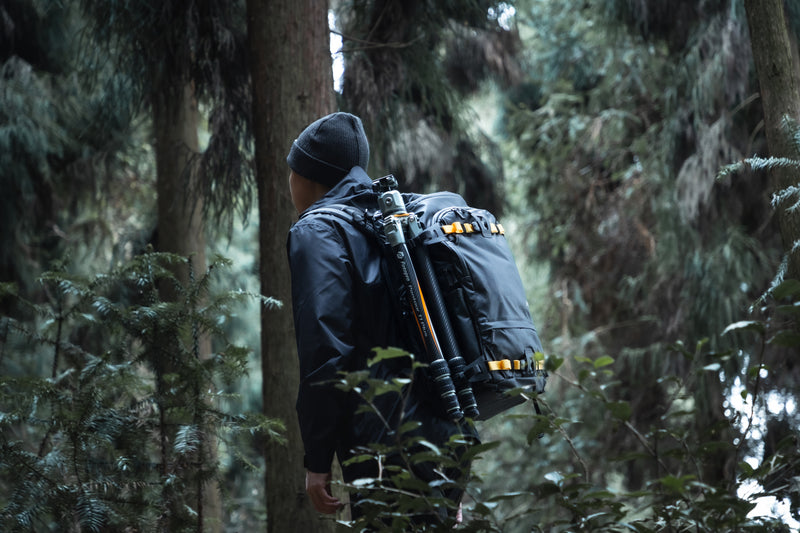 Fotopro T1 Plus camera tripod in outdoor hiking and mountain environments, easily carried in backpack. Provides excellent ground grip and stability on uneven surfaces such as forests, soil, rocks, and rugged trails. Perfect outdoor companion for hikers, landscape photographers, and adventure creators